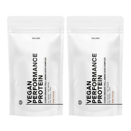 Zwei weiße, wiederverschließbare Beutel mit DALUMA VEGANES PERFORMANCE PROTEIN KAKAO DOUBLE stehen aufrecht und präsentieren diese vegane Bio-Proteinmischung mit minimalistischem schwarzem Text und dem Hinweis 