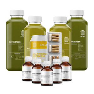 Erleben Sie die DALUMA GREEN JUICE PLUS SAFTKUR 5 TAGE: Wellness-Essentials, bestehend aus grünen Saftflaschen, einer Kombucha-Dose, Kapseln und fünf braunen Glasflaschen - hübsch arrangiert auf weißem Hintergrund für Ihre fünftägige Reinigung.