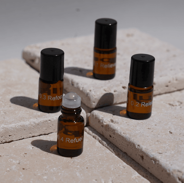 Vier kleine braune Glasflaschen mit schwarzen Verschlüssen, beschriftet mit "0.2 Refuel", "0.3 Refocus" und "0.4 Refuel", aus dem Nullpunkt NULLPUNKT DISCOVERY SET, sind auf hellen Steinfliesen ausgestellt. Eine weitere Produktbeschreibung ist nicht verfügbar.