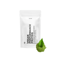 Ein weißer Beutel mit DALUMA VEGANES PERFORMANCE PROTEIN NEUTRAL steht aufrecht auf einem weißen Hintergrund, mit grünem Pulver und einem Blatt daneben, das dieses pflanzliche Protein als neutrales Premium-Proteinpulver hervorhebt.