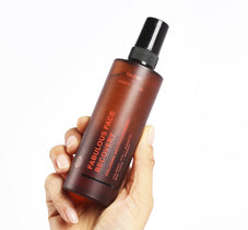 Eine Hand mit einer Flasche DALUMA FACE RECOVERY MIST GESICHTSSPRAY, ideal für einen erfrischten und strahlenden Teint.